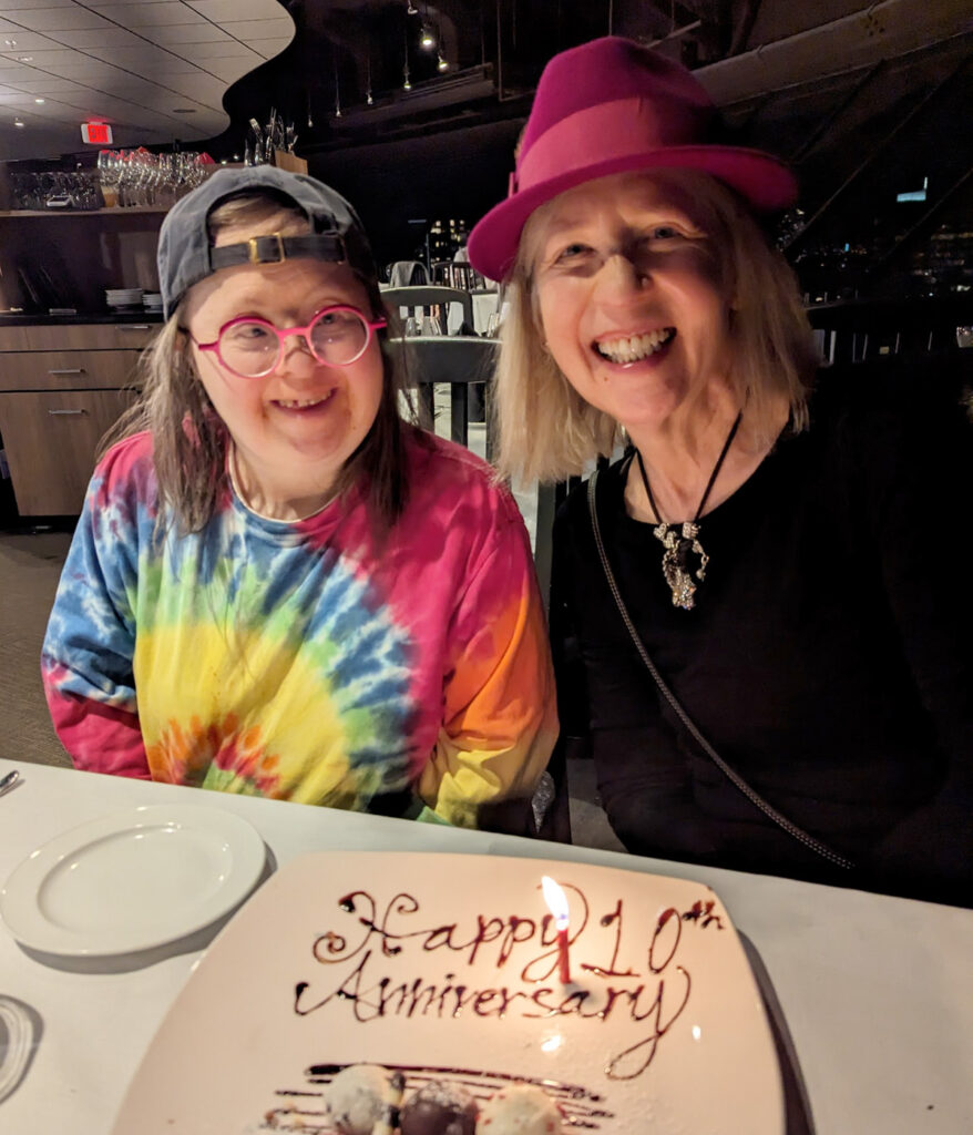 Teresa and Franke celebrate their tenth anniversary together at the Top of Vancouver, the city's revolving restaurant, in December 2023. The dessert says Happy 10th Anniversary